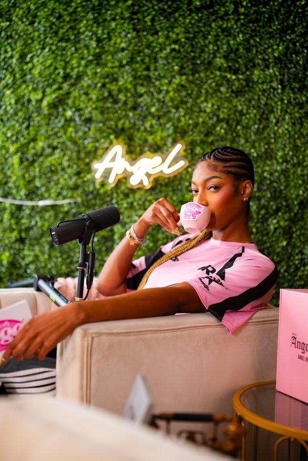 Angel Reese — podcast set with neon sign